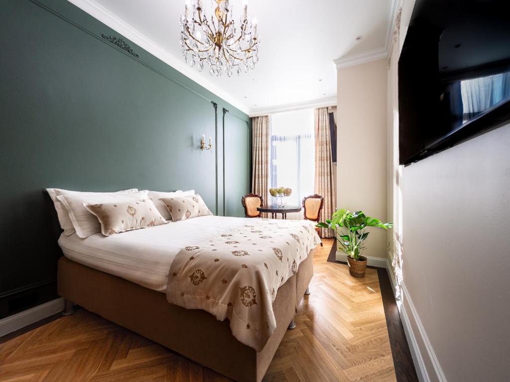 Elegant room with forest green paneled wall and herringbone parquet