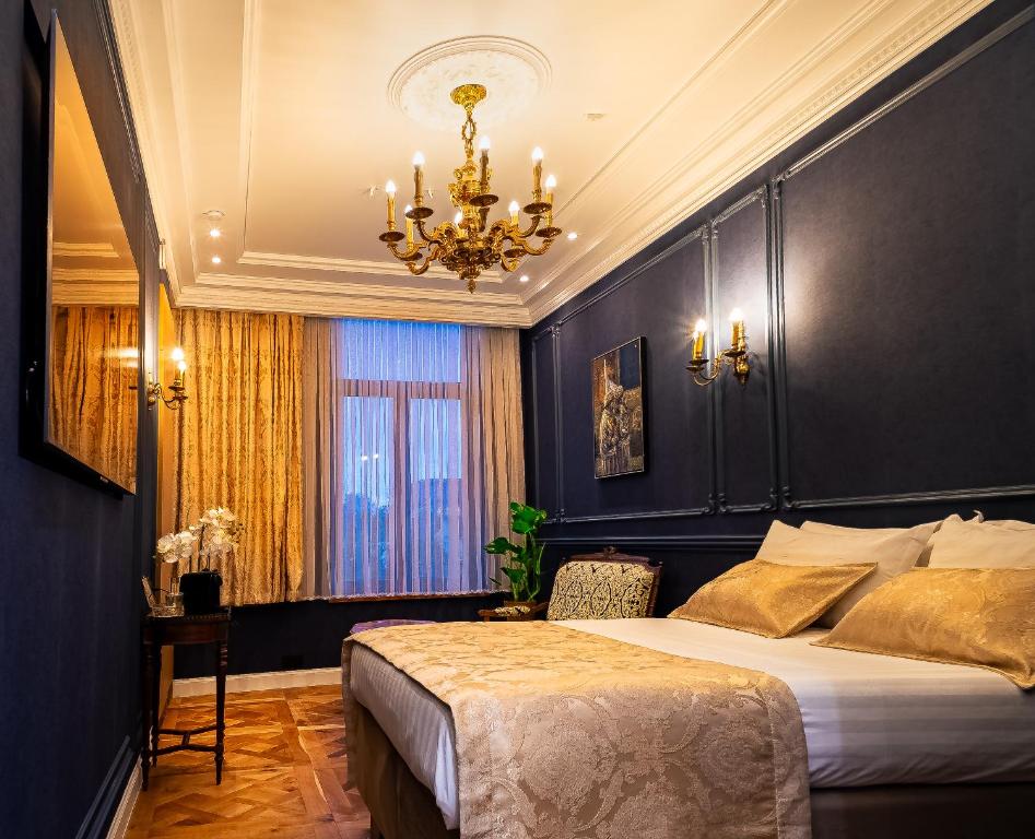Luxury suite with deep navy paneled walls, golden chandelier, and gold silk pillows