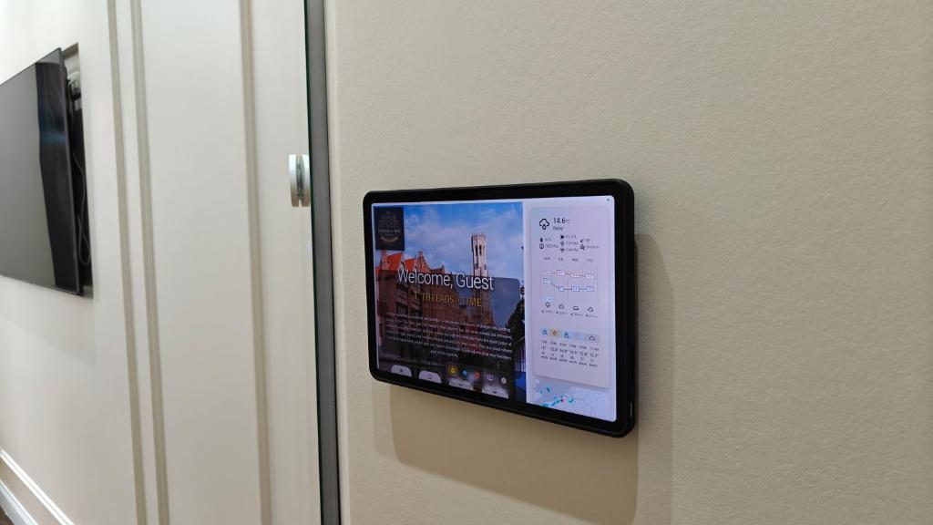 Wall-mounted smart tablet showing guest welcome screen
